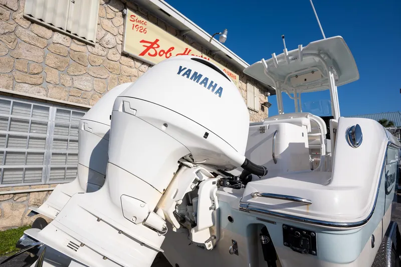 Slide: The Image of 2022 Robalo R242 boat with Yamaha outboard engines, parked near a stone building. - 34