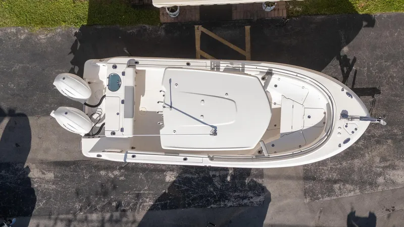Slide: The Image of Overhead view of a 2022 Robalo R242 boat with dual engines on pavement. - 35