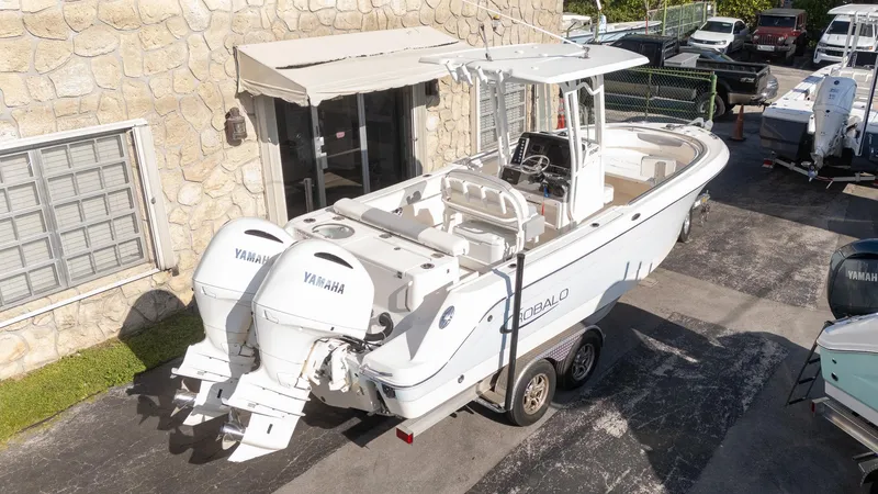 Slide: The Image of 2022 Robalo R242 boat with dual Yamaha engines on a trailer, parked outdoors. - 36
