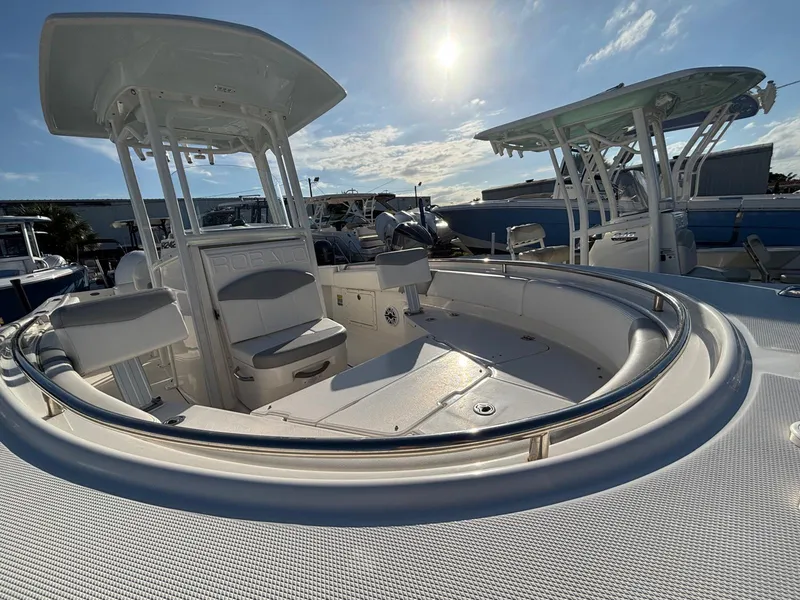 Slide: The Image of 2022 Robalo R242 boat with spacious deck and seating under a clear blue sky. - 6