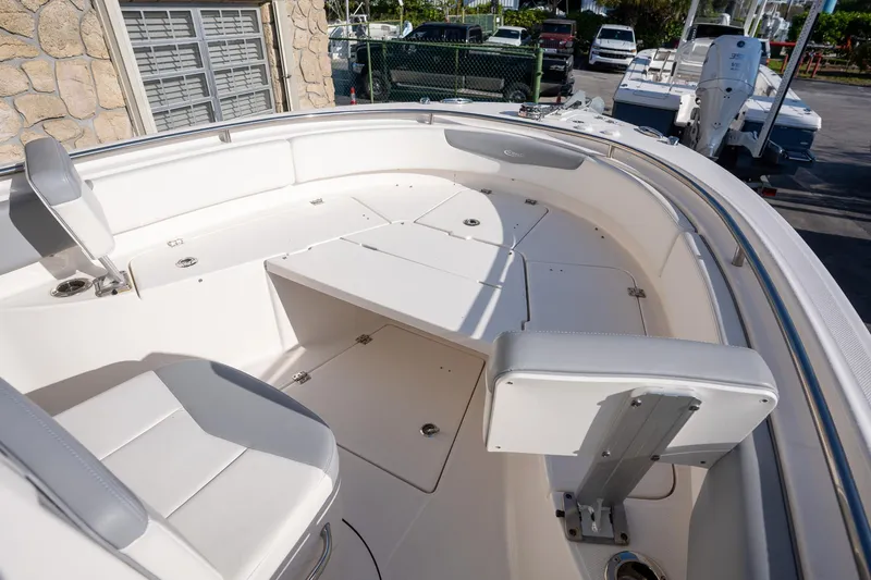 Slide: The Image of 2022 Robalo R242 boat interior with white seating and storage compartments. - 7