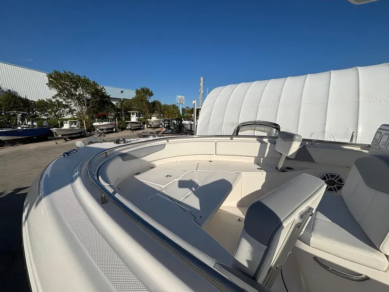Slide: The Image of 2022 Robalo R242 boat interior with seating, docked outdoors under clear blue sky. - 9