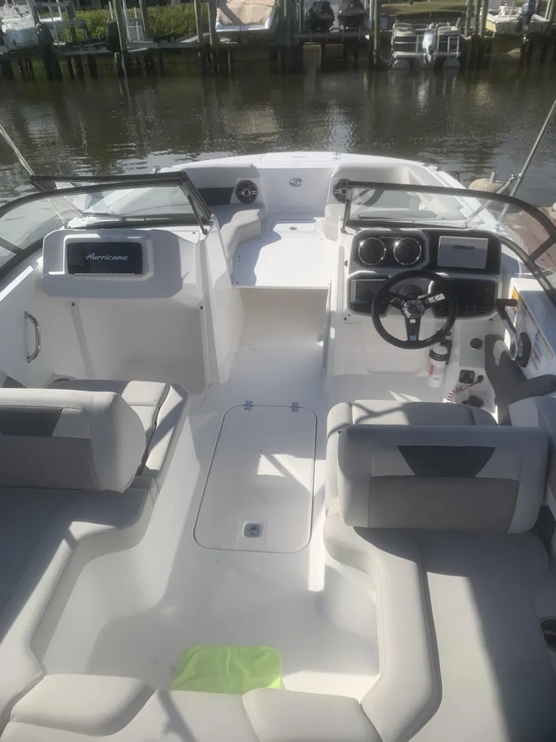 Slide: The Image of 2025 Hurricane SD 2050 boat interior with modern dashboard and seating, docked by the water. - 10