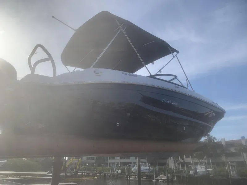 Slide: The Image of 2025 Hurricane SD 2050 boat with canopy, docked under a clear blue sky. - 2