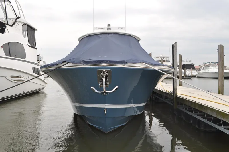Slide: The Image of 2023 Regulator 34 boat docked with blue cover, front view. - 1