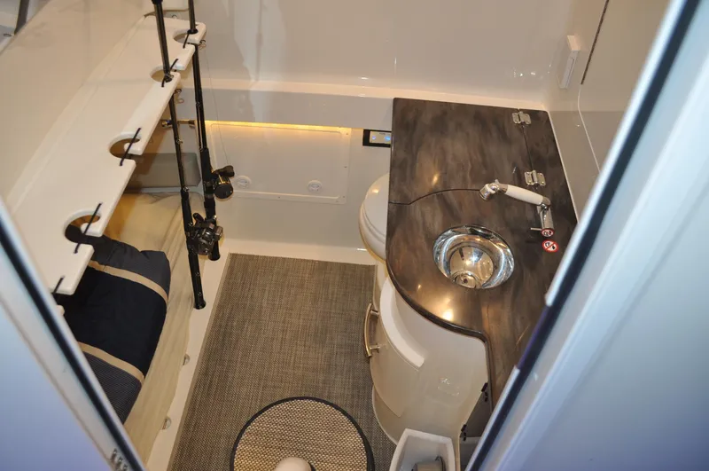 Slide: The Image of 2023 Regulator 34 boat interior with sink, toilet, and fishing rod storage. - 22
