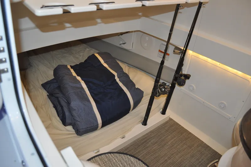 Slide: The Image of 2023 Regulator 34 cabin interior with bedding and fishing rods. - 23