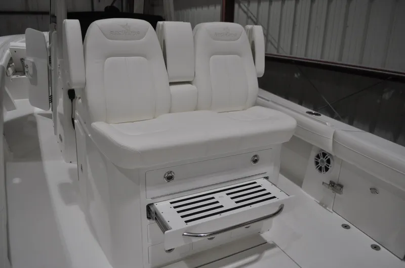 Slide: The Image of 2023 Regulator 34 boat interior with white cushioned seating and storage compartment. - 3