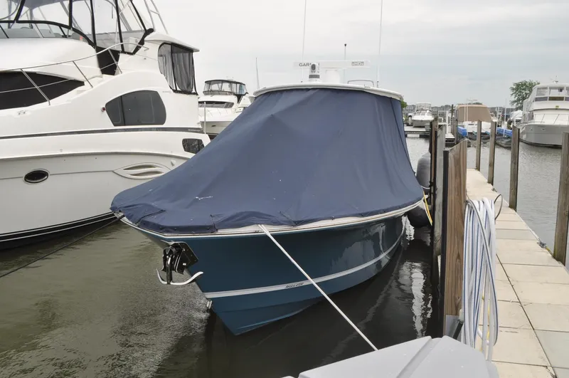 Slide: The Image of 2023 Regulator 34 boat docked with blue cover, marina background. - 32