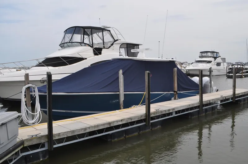 Slide: The Image of 2023 Regulator 34 boat covered at marina dock, surrounded by other yachts. - 33