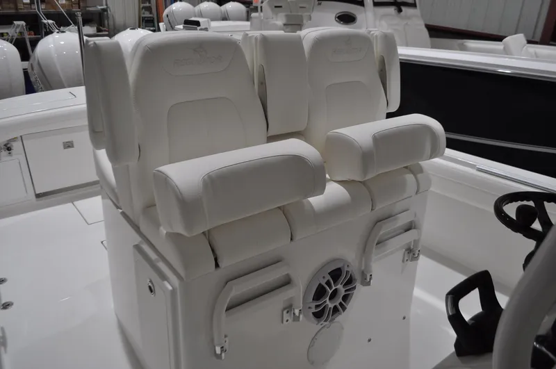 Slide: The Image of 2023 Regulator 34 boat with white cushioned seating and integrated speaker system. - 6