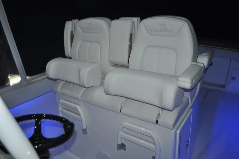 Slide: The Image of 2023 Regulator 34 boat interior with white cushioned seats and illuminated controls. - 8