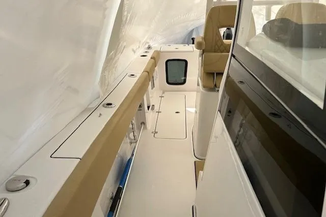 Slide: The Image of 2023 Sportsman Open 282 Center Console interior with beige seating and sleek design. - 44