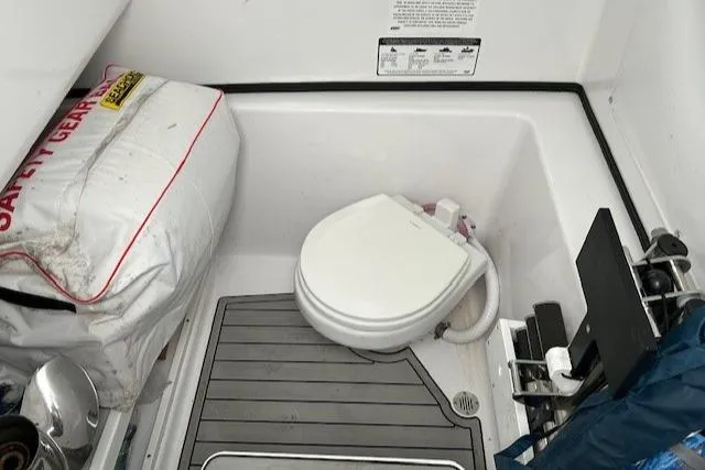 Slide: The Image of 2023 Sportsman Open 282 Center Console boat interior with toilet and safety gear. - 46