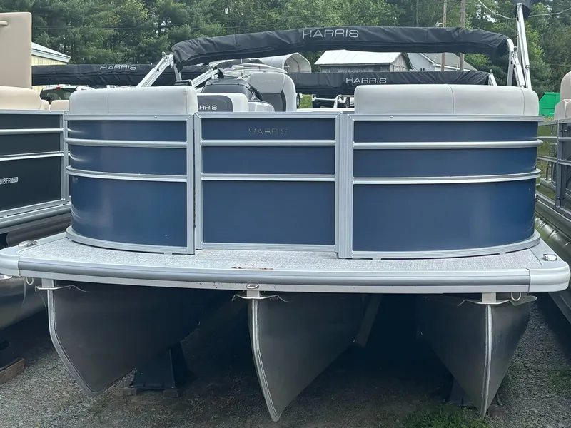 Slide: The Image of 2025 Harris Cruiser 210 SL pontoon boat, blue and silver, docked outdoors. - 12