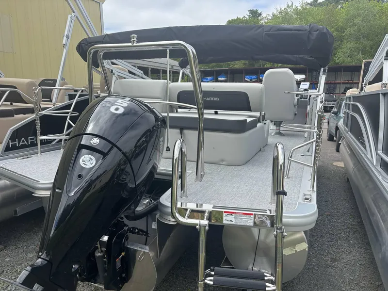 Slide: The Image of 2025 Harris Cruiser 210 SL pontoon boat with outboard motor, docked outdoors. - 14