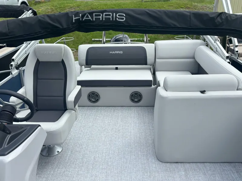 Slide: The Image of 2025 Harris Cruiser 210 SL boat interior with gray seating and steering wheel. - 16