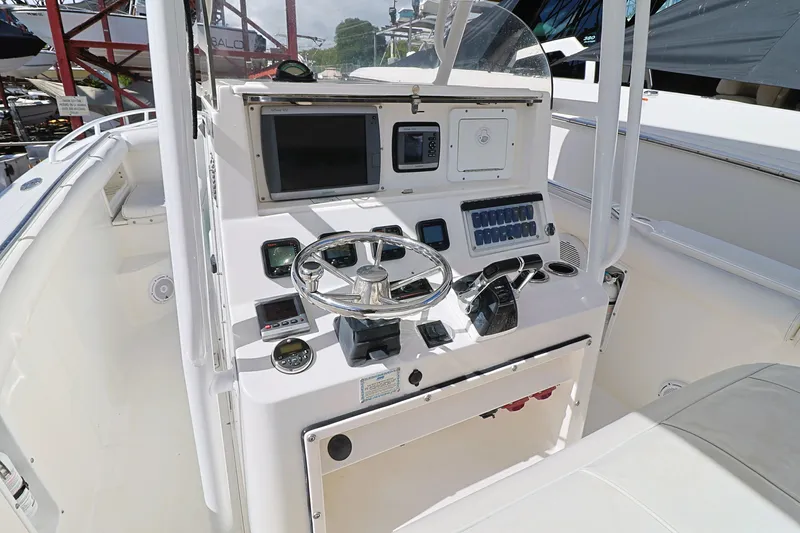 Slide: The Image of 2004 Marlago 35 Sport Cuddy boat dashboard with steering wheel and control panel. - 10