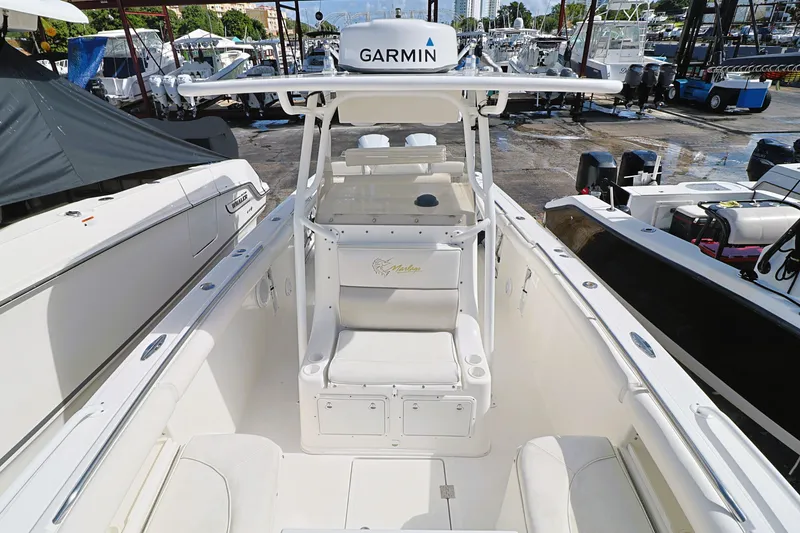 Slide: The Image of 2004 Marlago 35 Sport Cuddy boat with Garmin equipment, docked in a marina. - 13
