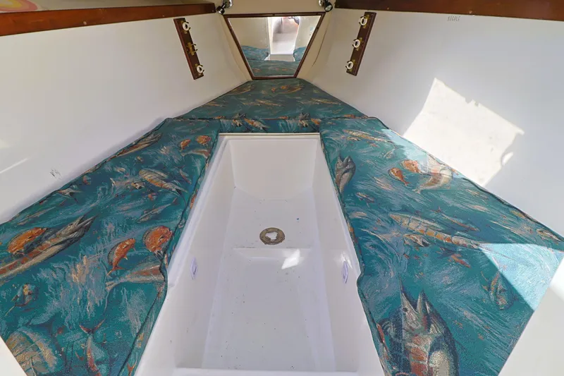 Slide: The Image of 2004 Marlago 35 Sport Cuddy interior with fish-patterned cushions and white flooring. - 18