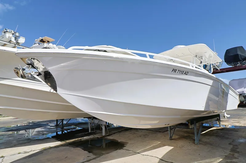 Slide: The Image of 2004 Marlago 35 Sport Cuddy boat on dry dock under clear blue sky. - 2