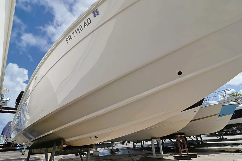 Slide: The Image of 2004 Marlago 35 Sport Cuddy boat on dry dock under a clear blue sky. - 21