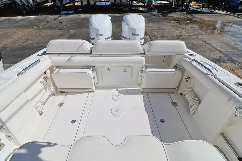 Slide: The Image of 2004 Marlago 35 Sport Cuddy boat interior with white seating and twin engines. - 7