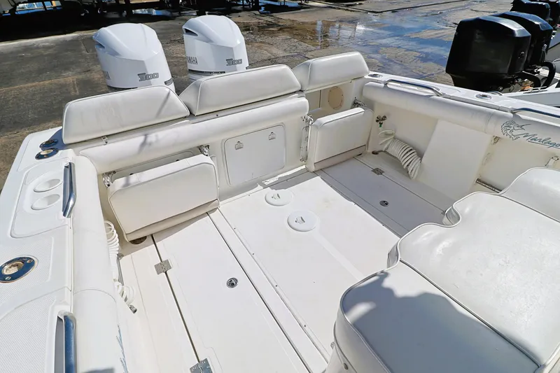 Slide: The Image of 2004 Marlago 35 Sport Cuddy boat interior with white seating and twin engines. - 8