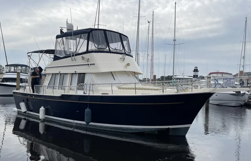 Slide: The Image of 2005 Mainship 430 Aft Cabin 3SR Trawler docked in a marina. - 0