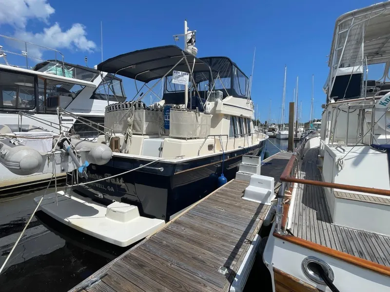 Slide: The Image of 2005 Mainship 430 Aft Cabin 3SR Trawler docked at marina under clear blue sky. - 1