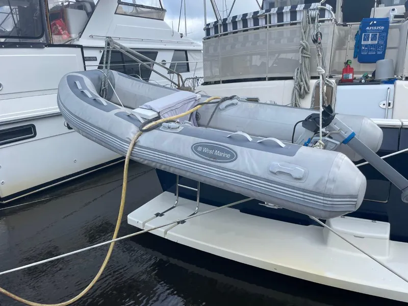 Slide: The Image of 2005 Mainship 430 Aft Cabin Trawler with inflatable dinghy docked at marina. - 11
