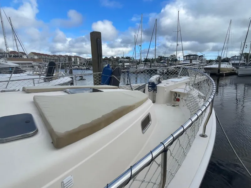 Slide: The Image of 2005 Mainship 430 Aft Cabin Trawler docked in a marina, showcasing deck and railing. - 12