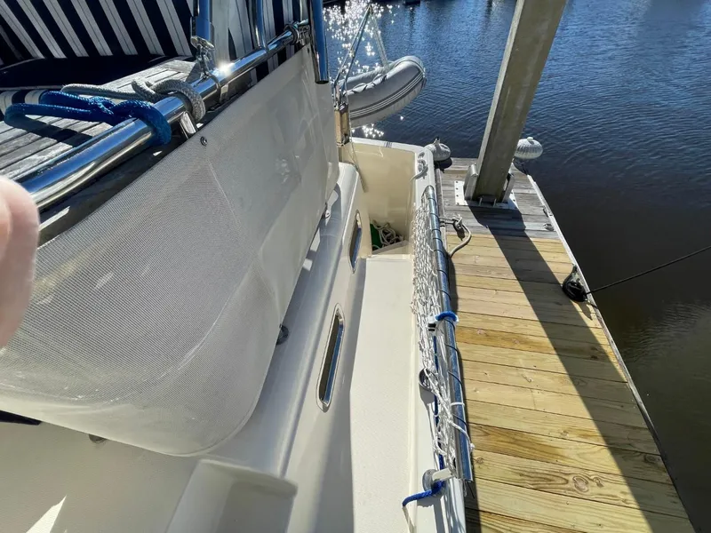 Slide: The Image of 2005 Mainship 430 Aft Cabin Trawler docked, showcasing deck and railing details. - 13
