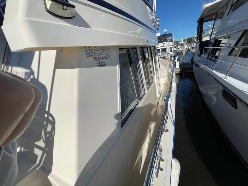 Slide: The Image of 2005 Mainship 430 Aft Cabin Trawler docked at marina, side view. - 16