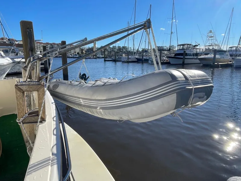 Slide: The Image of 2005 Mainship 430 Aft Cabin Trawler with dinghy at marina. - 17