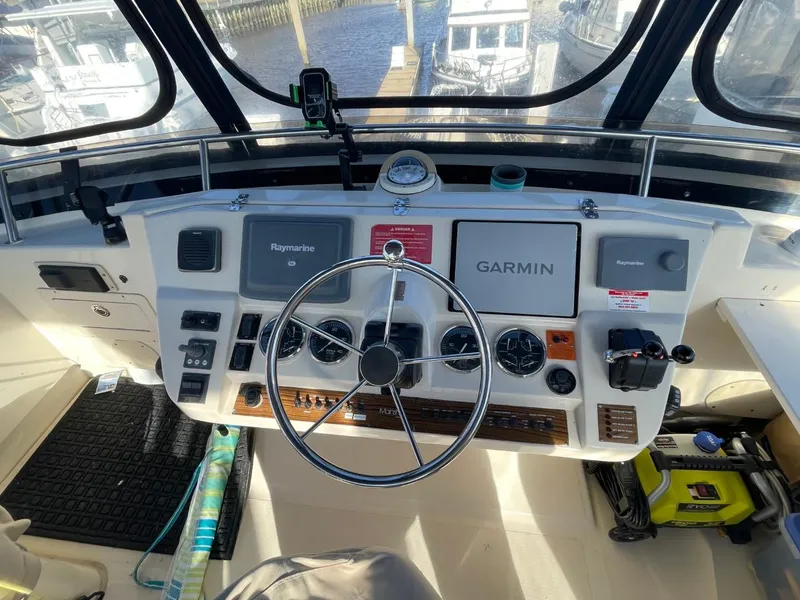 Slide: The Image of 2005 Mainship 430 Aft Cabin Trawler helm with Garmin and Raymarine navigation systems. - 18