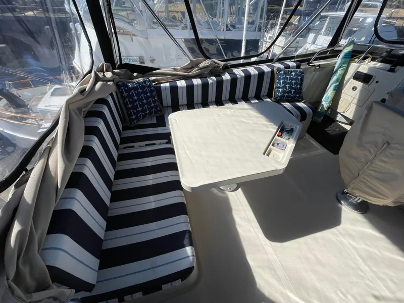 Slide: The Image of 2005 Mainship 430 Aft Cabin Trawler interior with striped seating and table. - 27