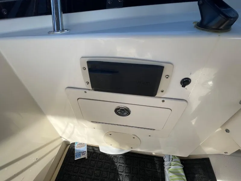 Slide: The Image of 2005 Mainship 430 Aft Cabin Trawler interior detail, featuring control panel and storage compartment. - 30
