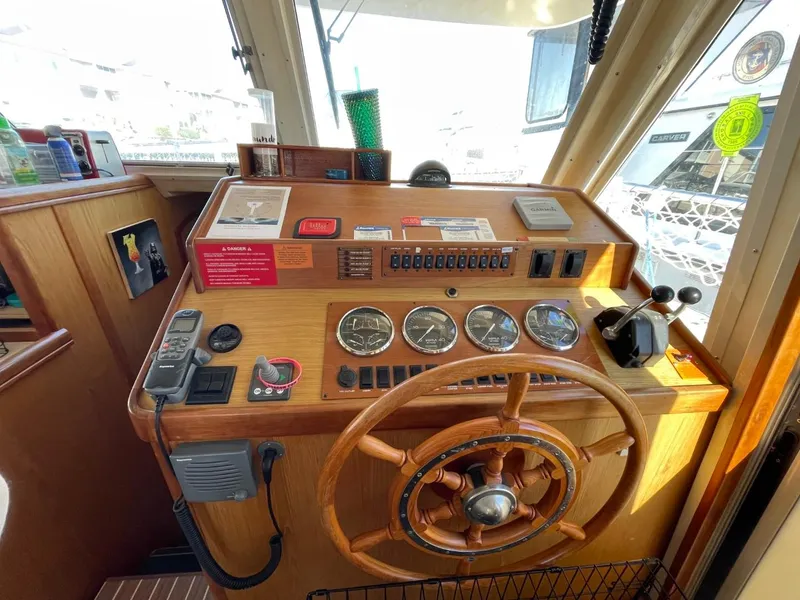 Slide: The Image of 2005 Mainship 430 Aft Cabin Trawler helm with wooden wheel and navigation instruments. - 33