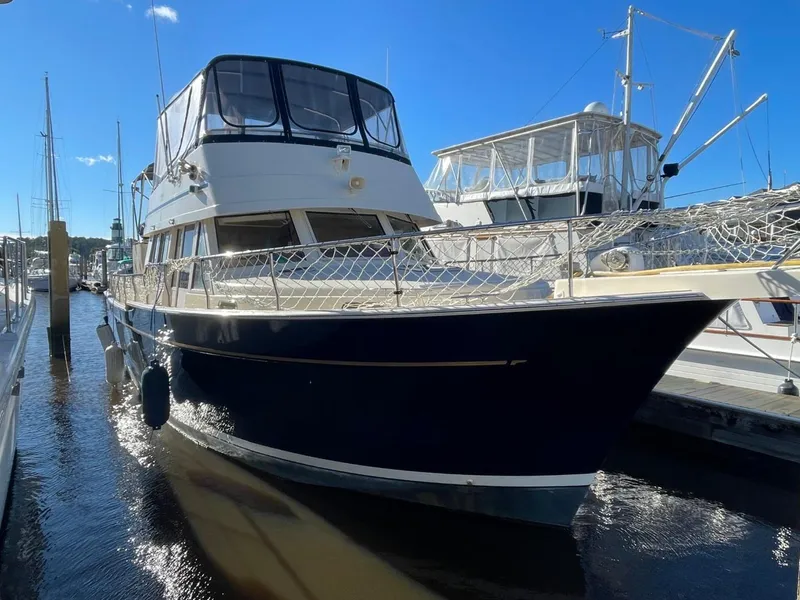 Slide: The Image of 2005 Mainship 430 Aft Cabin 3SR Trawler docked at marina under clear blue sky. - 4
