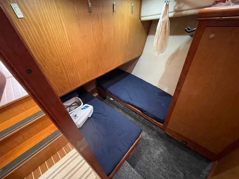 Slide: The Image of 2005 Mainship 430 Aft Cabin Trawler interior with twin beds and wooden cabinetry. - 41