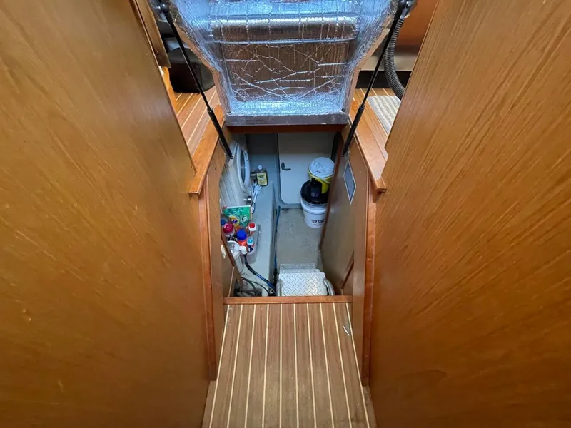 Slide: The Image of Engine room access in 2005 Mainship 430 Aft Cabin 3SR Trawler, featuring wooden steps and equipment. - 46