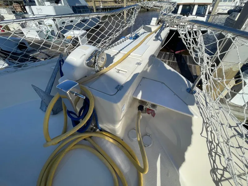 Slide: The Image of 2005 Mainship 430 Aft Cabin Trawler deck with ropes and anchor, docked at marina. - 51