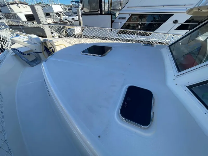 Slide: The Image of 2005 Mainship 430 Aft Cabin Trawler deck with hatches, docked at marina. - 53