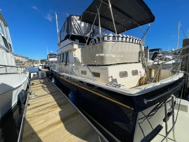 Slide: The Image of 2005 Mainship 430 Aft Cabin 3SR Trawler docked at marina under clear blue sky. - 8