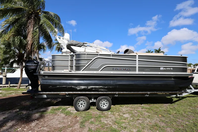 Slide: The Image of 2017 Ranger Reata 200F pontoon boat on trailer, parked near palm trees. - 13