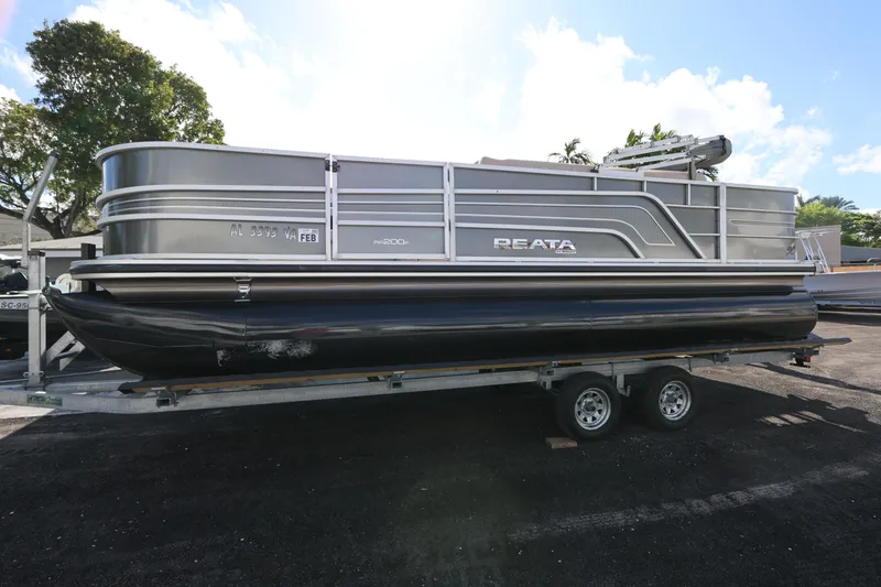 Slide: The Image of 2017 Ranger Reata 200F pontoon boat on trailer, parked outdoors. - 18