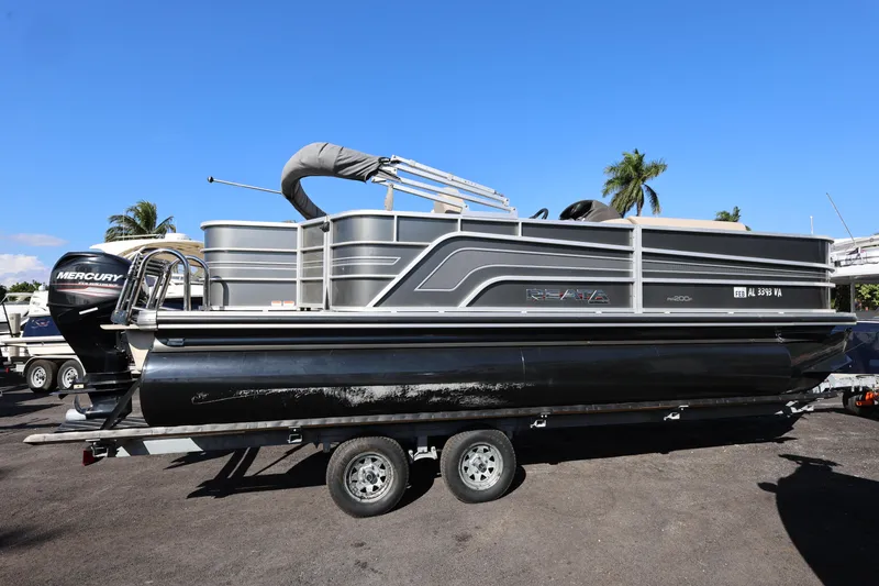 Slide: The Image of 2017 Ranger Reata 200F pontoon boat on trailer, parked outdoors. - 24