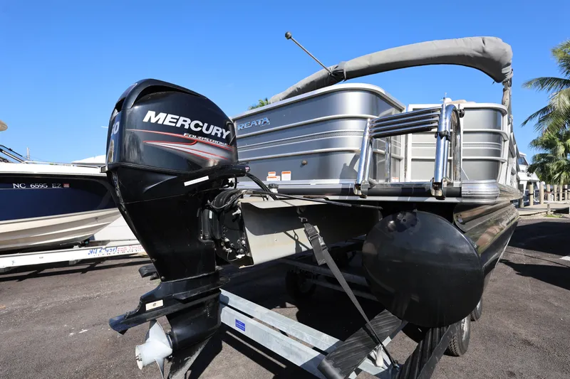 Slide: The Image of 2017 Ranger Reata 200F pontoon boat with Mercury outboard motor, parked on trailer. - 25