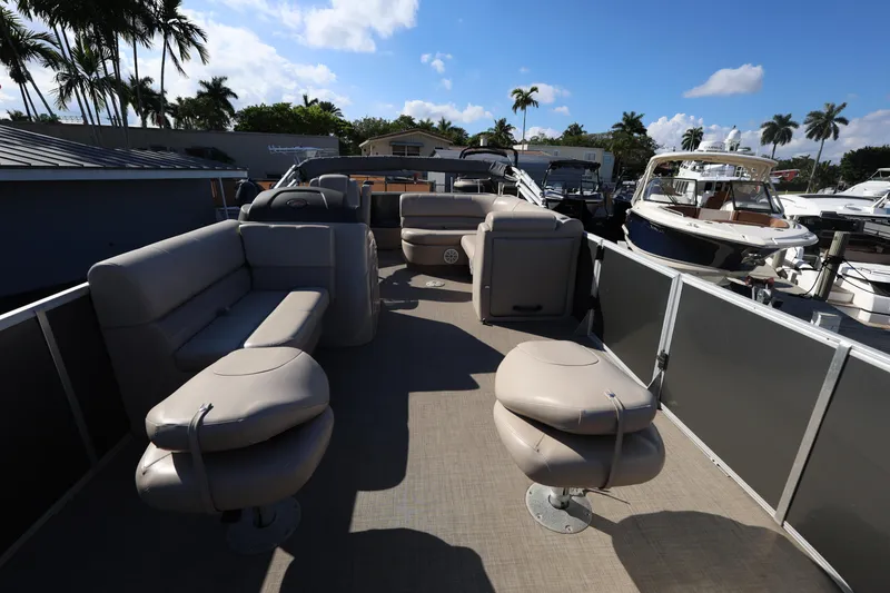 Slide: The Image of 2017 Ranger Reata 200F pontoon boat with spacious seating at a marina. - 29